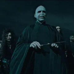 Lord Voldemort, jak miał wyglądać, w otoczeniu śmierciożerców, z różdżką w dłoni.